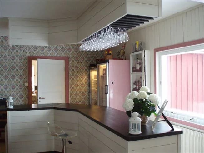 En hemtrevlig och varm interiör på Vålågårdens värdshus, med trädetaljer i tak och golv, en mysig belysning, samt synliga köks- och möbeldelar som ger en inbjudande känsla.