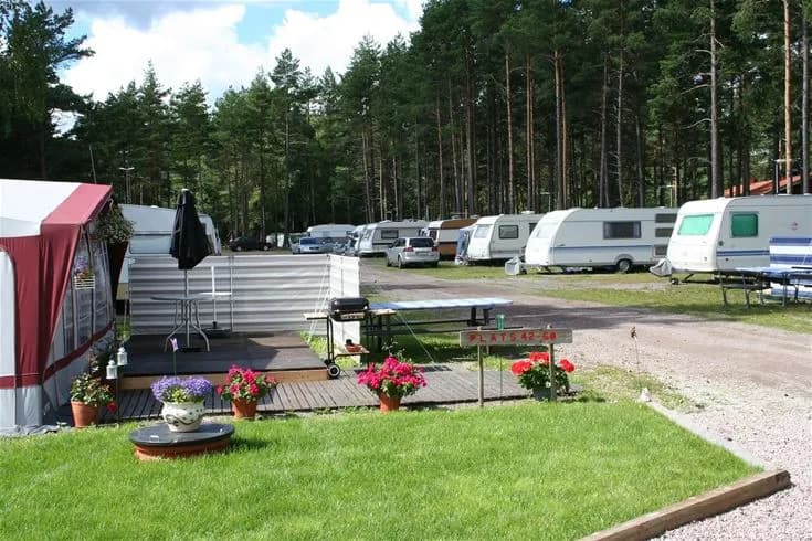 Utsikt över en campingplats med flera husvagnar parkerade i grönskande omgivningar vid Strandstuvikens havsbad & camping.