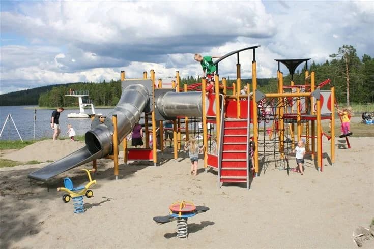 En lekplats med rutschkana och lekutrustning, barn leker i en park vid Saiva Camping & Stugby.