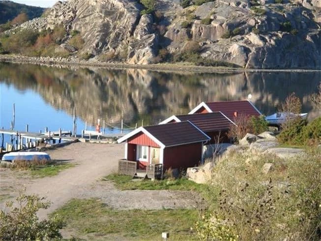 En naturskön vy över Rörviks camping med klippiga kustlinjer och en sjö i förgrunden.