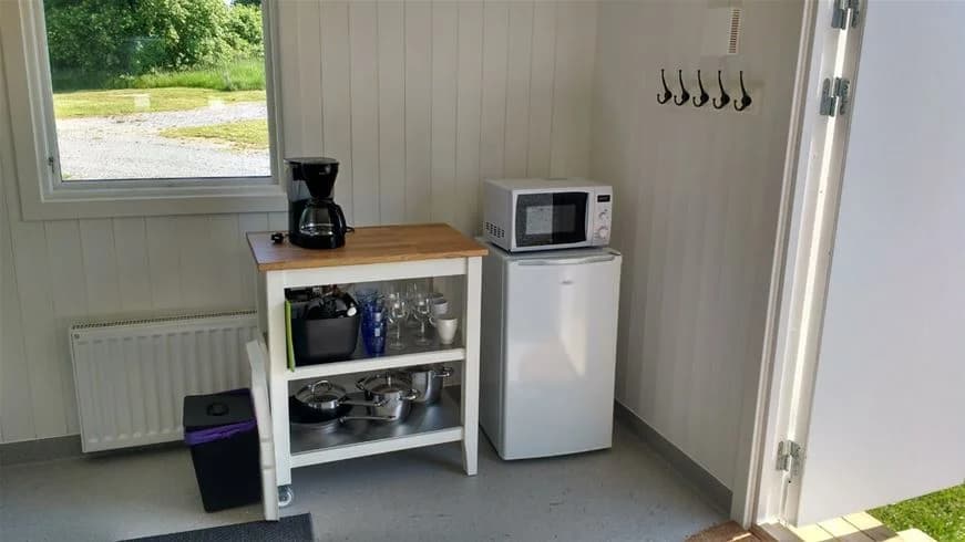 En välstädat campingkök med träinredning och aluminiumdetaljer på Norrtälje Camping.