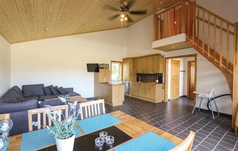 Alt-text: Interiörbild från Norje Boke Camping med golv och tak i trä, samt trämöbler som skapar en varm och inbjudande atmosfär.