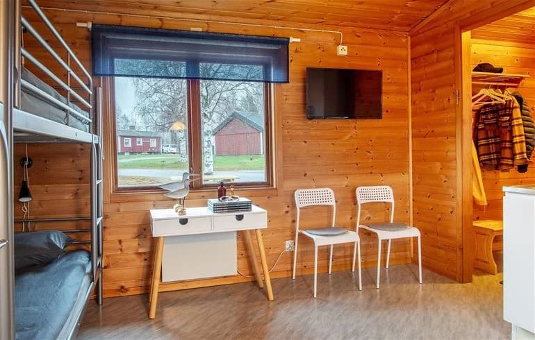 En trästuga med trägolv och träpaneler, typisk för Nordmalings camping.