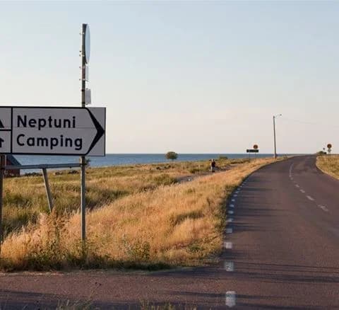 En sport- och fritidsfordon parkerad vid Neptuni camping omgiven av frodig natur, redo för en roadtrip.
