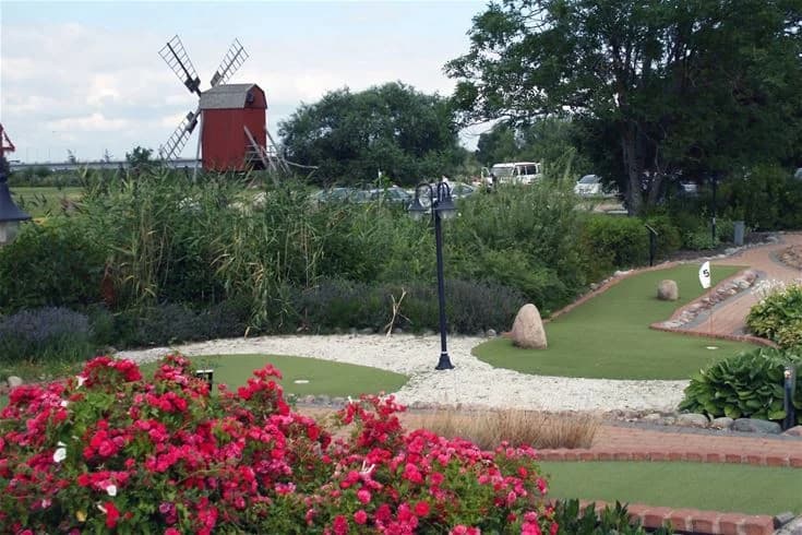 En grönskande campingområde vid Möllstorps camping med frodiga växter, blommor och buskar. En välskött trädgård med vårkänsla omgiven av naturlig landskapsarkitektur.