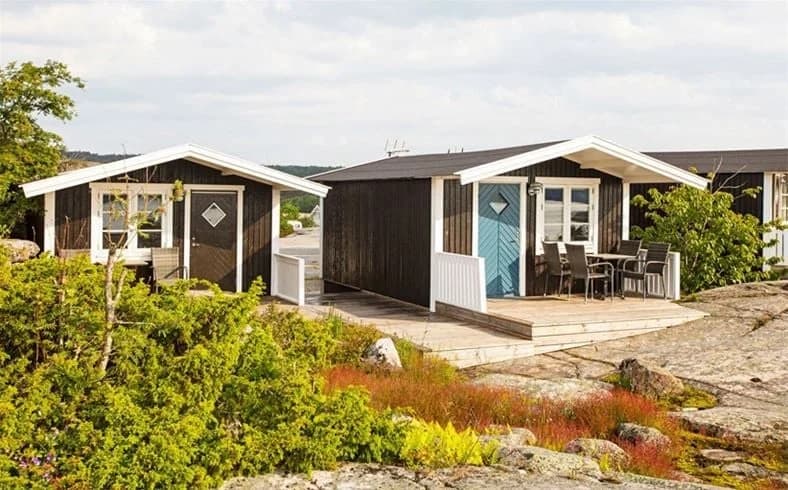 En naturskön campingplats med flera mindre stugor omgivna av grönska på Lökholmens camping.