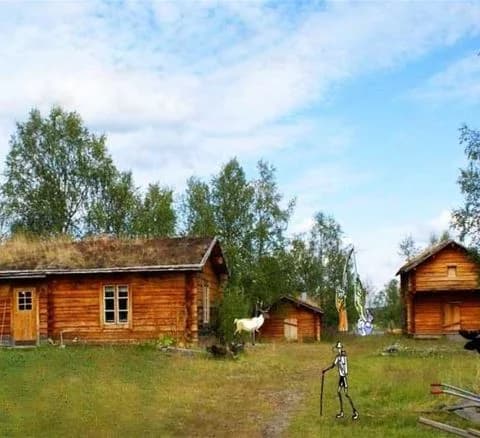 En mysig timmerstuga belägen på en naturskön campingplats i ett lantligt område, omgiven av växter och öppet landskap.