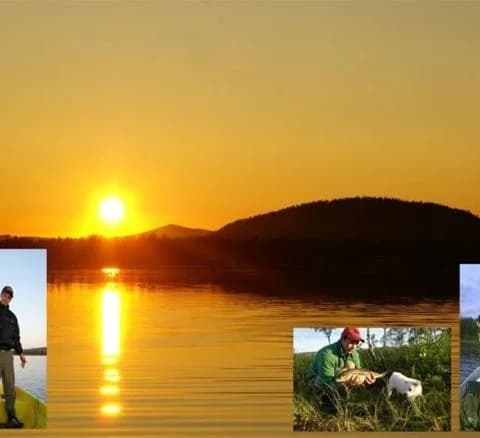 En stilla sjö vid Karesuando Camping & Rekreation i gryningen, med mjuka färger från soluppgången reflekterade i vattnet och omgivande landskap.