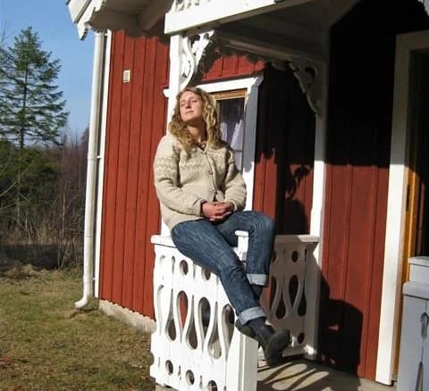 En grupp människor klädda i vintermode står och ler vid Jälluntofta camping. De har på sig jeans, stövlar, halsdukar och aktiva byxor, omgivna av en snöig natur.