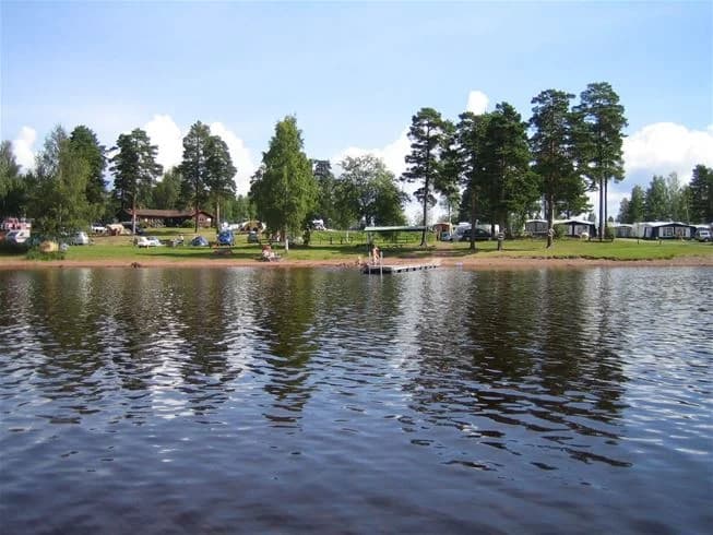 En lugn vattenväg omgiven av frodig grönska, vid Sollerö Camping, idealisk för avkopplande friluftsliv och rekreation.