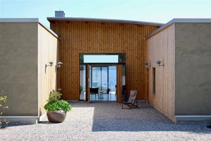 En liten, pittoresk byggnad vid namn Sagaliden, med träpanel i olika nyanser. Området kännetecknas av betong och trädetaljer samt stenbelagd mark. Det är dagsljus och miljön ger en inbjudande känsla av rustik charm.