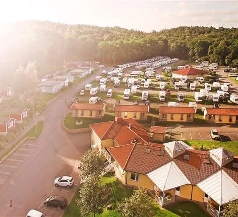 En vy över Lisebergsbyns parkeringsplats med flera parkerade bilar.