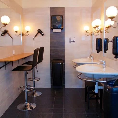 En stilren badrumsinteriör på Malmköpings Bad & Camping med en modern handfat och blandare, diskret belysning och fräscha golv.