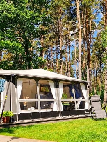 En campingplats vid Rafshagsudden i Kalmar med skyddande trädskugga och utomhusmöbler för avkoppling.