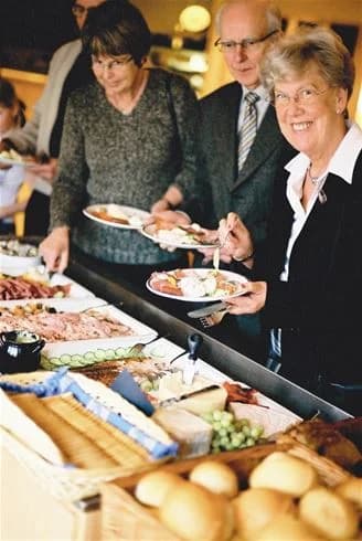Alt-text: En buffé med olika maträtter på Gullbrannagården, där färgglada och aptitretande rätter är upplagda, redo att avnjutas av besökare.