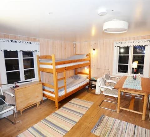 En rustik stuga med träinredning, möbler och trägolv som ger en varm och inbjudande känsla. 