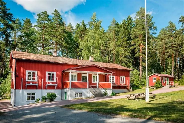 En vidsträckt grön gräsyta vid Bredsands bad & camping, med plats för camping och rekreation.