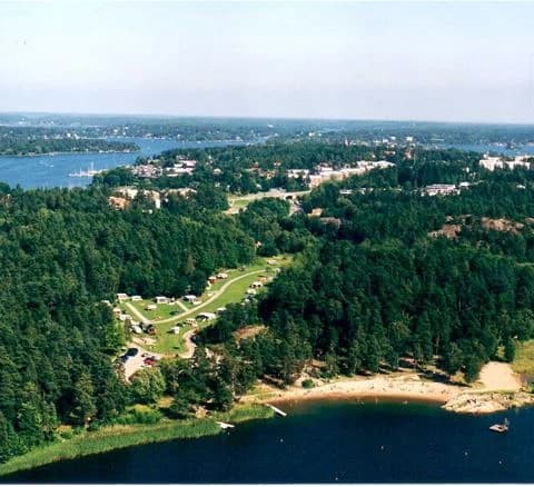 Flygfoto över Waxholms camping, med kustnära landformer som vikar, öar och en vidsträckt kustlinje synliga.