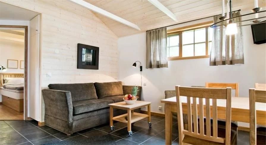 En interiör av ett strandnära semesterboende vid Årsunda strandbad. Rummet har träinredning med trätak, golv och dörrar, vilket skapar en varm och rustik atmosfär.