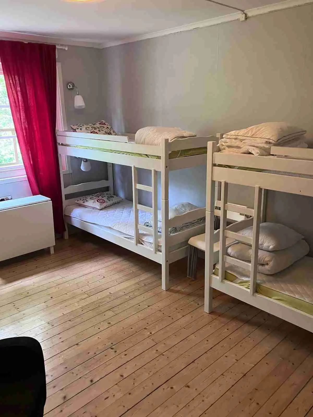 En trästuga med våningssäng, synliga trägolv och enkel inredning på Bredsands bad & camping.