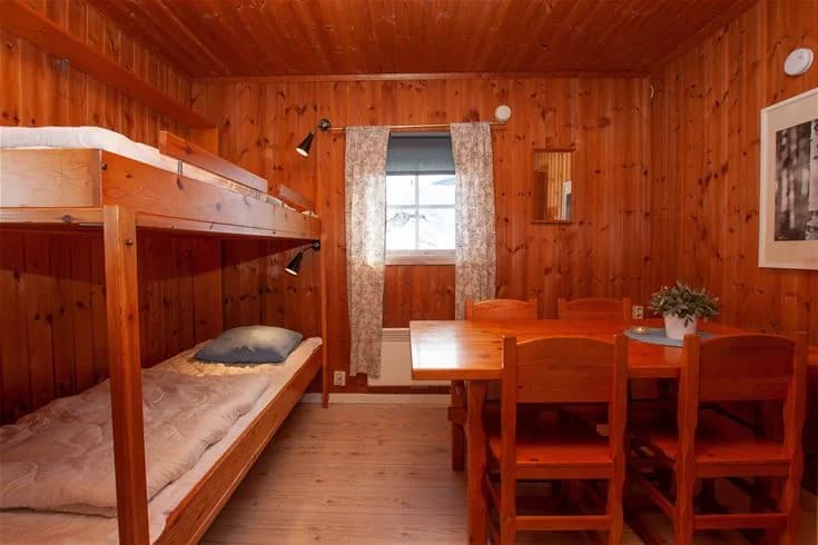 En träbyggnad på Rätans camping, med synliga takbjälkar och träpaneler som ger en rustik och hemtrevlig känsla.