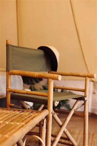 En campingplats vid kusten med bambustrukturer och trädetaljer, omgiven av naturskön miljö vid Trosa havsbad.