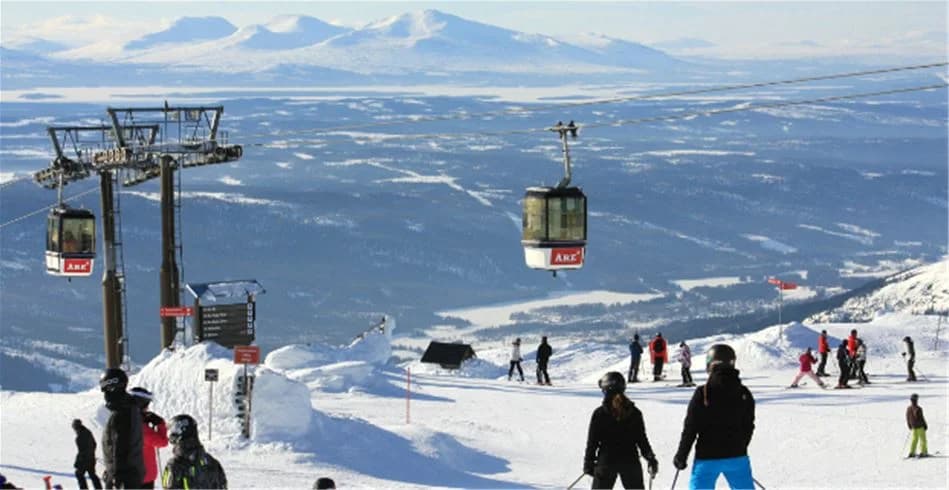 En bild av Åre camping omgiven av snötäckta berg och vinterlandskap, med tydliga spår av glaciära formationer och skidbackar i närheten.