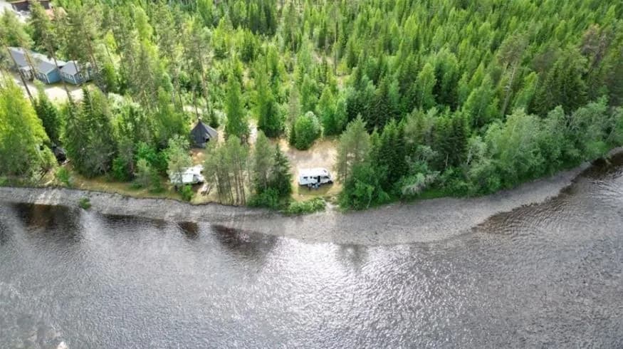 En lugn flod omgiven av grönskande träd och skog vid Ammeråns fiskecamp.