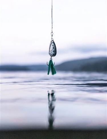 En närbild av ett hantverk gjort av naturmaterial vid Ammeråns fiskecamp, med silverfärger och rep som detaljer i en stillebenskomposition.