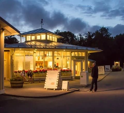 En trästuga med skuggiga uteplatser och grönskande gård i Lisebergsbyn, en populär plats för besökare att bo och koppla av.