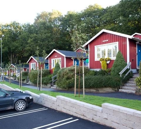 En pittoresk stuga omgiven av välskötta trädgårdar och buskar i Lisebergsbyn.