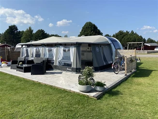 En campingplats med tält och skyddande markiser som erbjuder skugga vid Harge bad & camping.