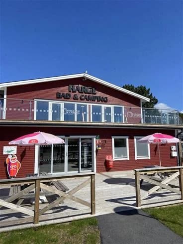 En bild av Harge Bad & Camping som visar en restaurang och värdshus i en naturskön miljö.