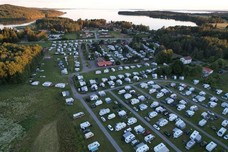 Flygbild över Harge Bad & Camping vid kusten, med rekreationsområde inklusive park och vik sett från ovan.