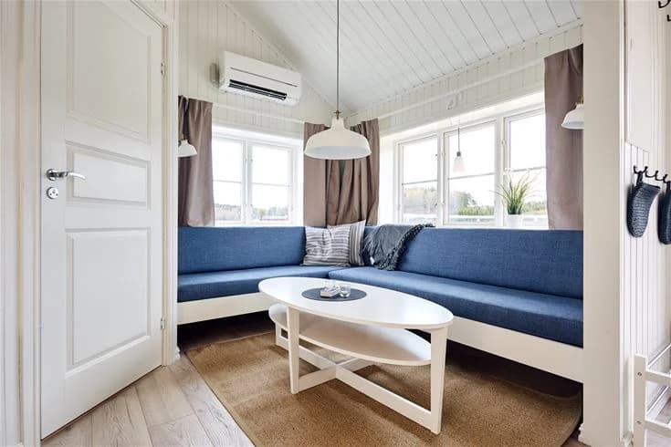 Ett interiört foto av en stuga vid lagunen camping & stugor. Rummet har ett trätema med trägolv och tak, möbler inkluderar en dörr och andra hemtrevliga detaljer.