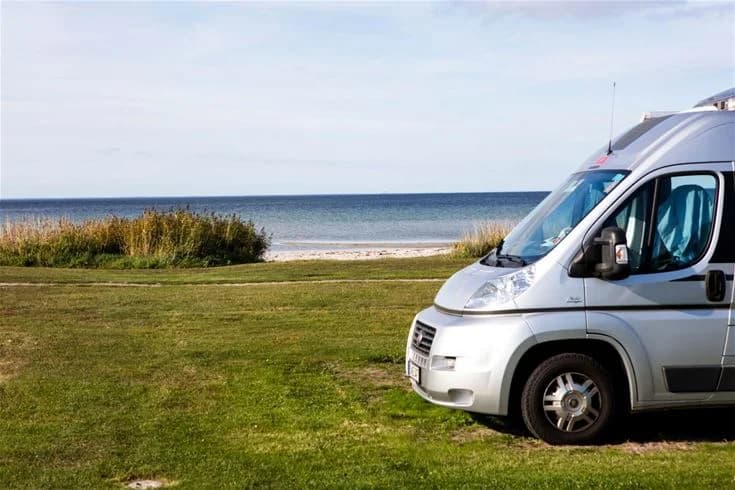 Bild av en husbil parkerad nära havet vid Gröndals camping & stugor, omgiven av kust och strand. Perfekt för besökare som söker en campingupplevelse med närhet till natur och hav.