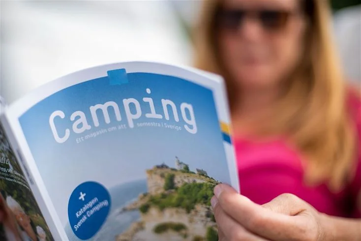 En somrig broschyr för Gröndals Camping & Stugor med bilder av campingliv och natursköna omgivningar. Texten marknadsför avkoppling och fritidsaktiviteter.