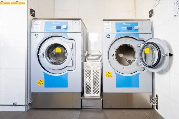 En tvättstuga med tvättmaskin och torktumlare på Gröndals camping & stugor.