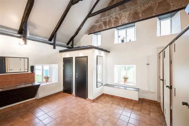 Interiörbild av en stuga på Gröndals camping & stugor, med ett ljust tak, kaklat golv och mjuk belysning som skapar en inbjudande atmosfär.