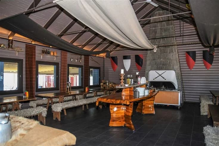 En modern och stilren interiör i en gemensamhetslokal på Ursand Resort & Camping. Rummet har ljusa väggar och golv, takbelysning, och består av bekväma möbler som stolar och soffor. En inbjudande och avslappnande atmosfär för besökare att njuta av.