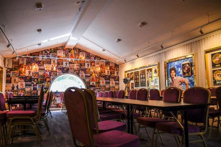 Interiörbild av Ursand Resort & Camping, som visar en mysig restaurangmiljö med taktill belysning och moderna möbler. Stolar och bord är prydligt arrangerade, och väggarna är dekorerade med tavelramar och inredningsdetaljer.