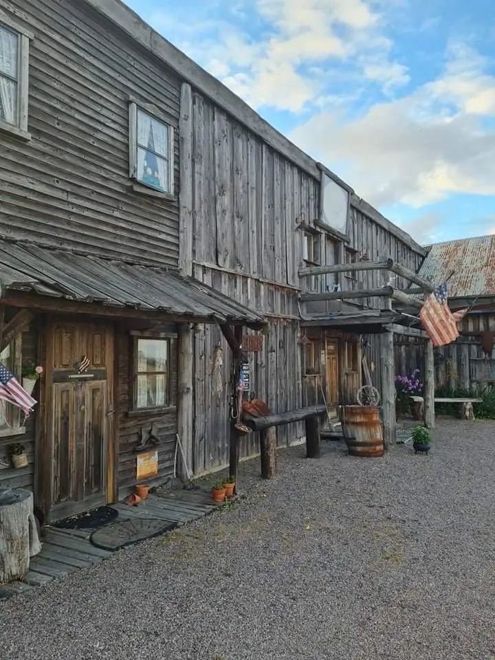 En träbyggnad med vildavästern-tema, med kraftig träpanel och tak av korrugerad plåt, markerad som en ställplats för besökare.