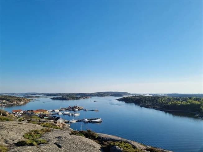 En vy över Grebbestadfjorden med blått vatten, kustlinje och horisont i fjärran.