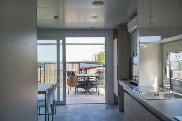 Bild av ett inbjudande interiör på Kneippbyn Resort Visby. Trägolv sträcker sig genom rummet, som är smakfullt inrett med moderna möbler, ett ljust tak och en diskdisk i trä som ger en hemtrevlig och stilren känsla.