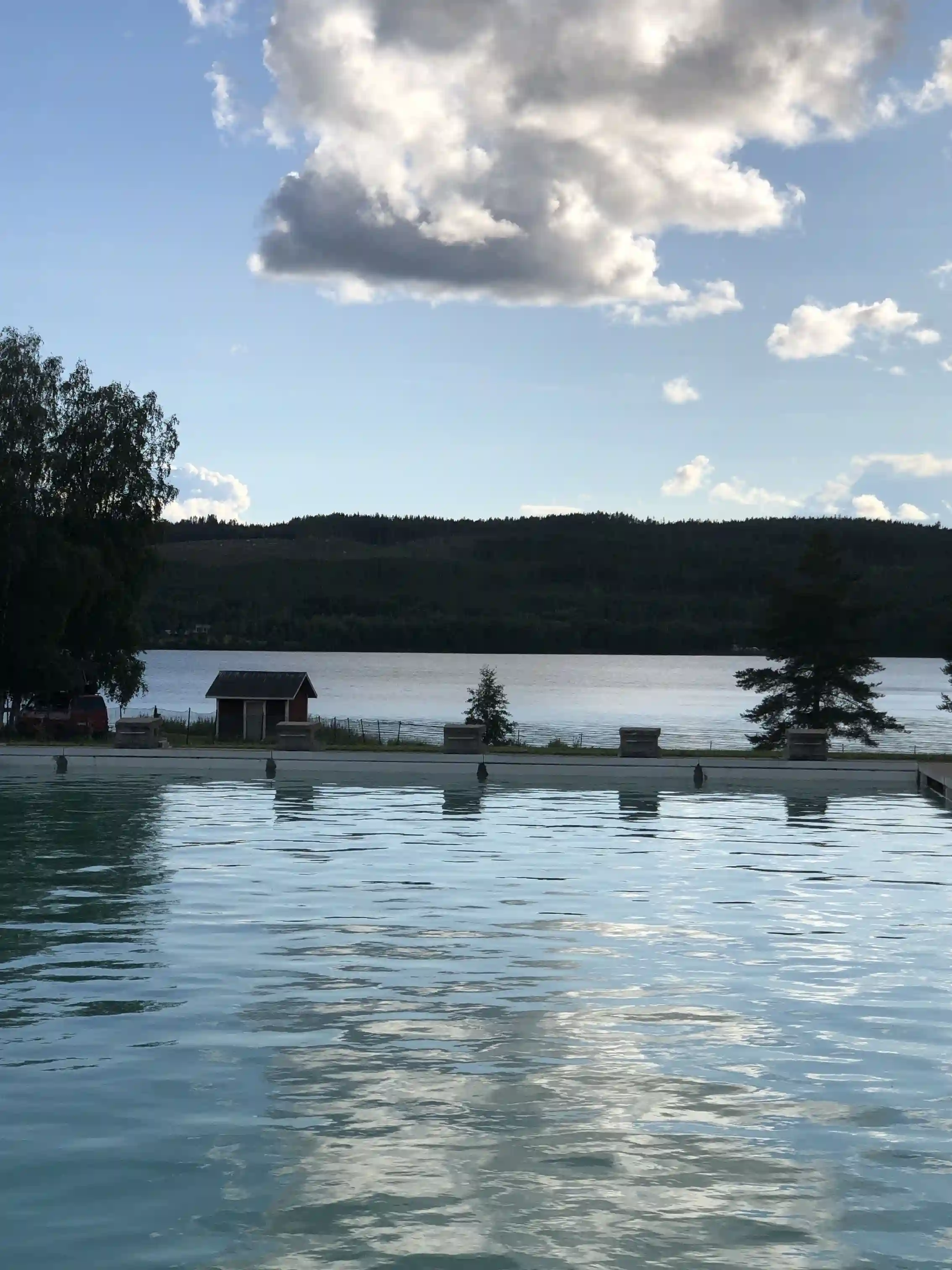 Utsikt över en sjö vid Rätans camping, med ett klart vatten och omgivande grönska som skapar en inbjudande miljö för rekreation och avkoppling.