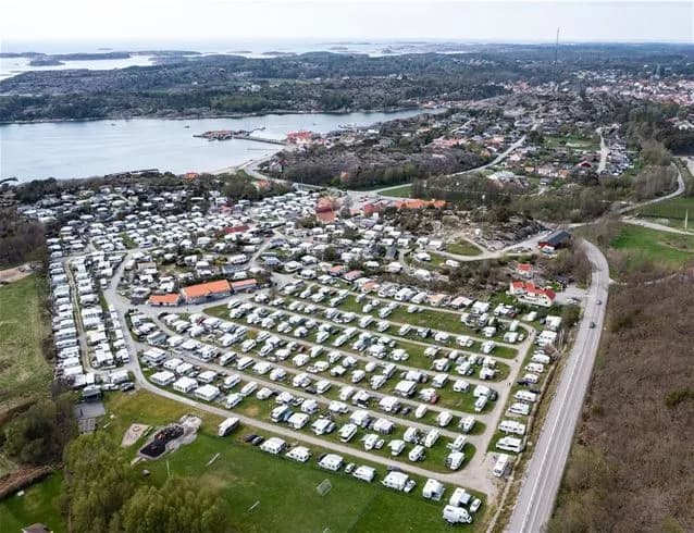 Flygbild över Grebbestadfjorden som visar en kust med parker och badortsmiljö, samt en bukt med rekreationsområden.