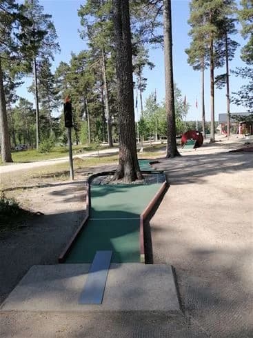 En naturskön park vid norra dellen med gröna träd och öppna ytor, idealisk för familjecamping och utomhusaktiviteter.