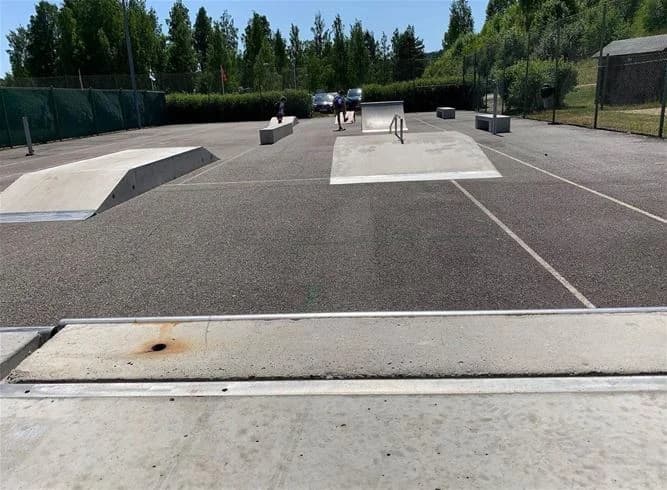 En skatepark med betongramper och intilliggande parkeringsplats på Sollefteå Camping.
