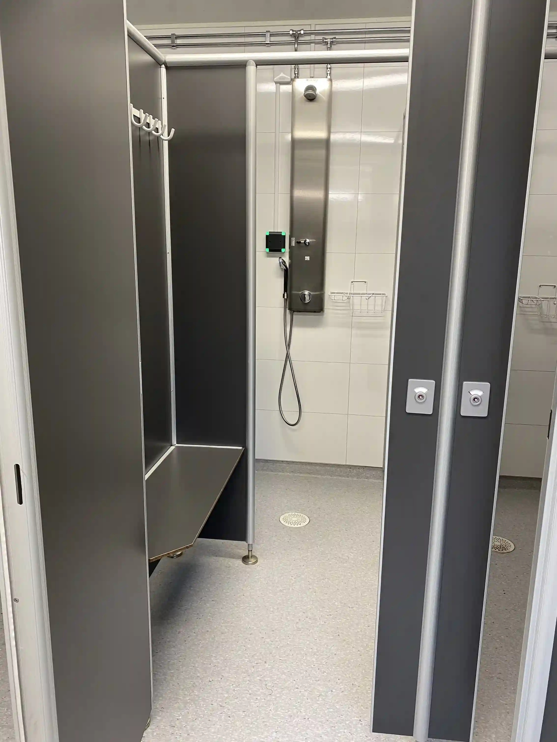 En närbild av en modern metallisk design, förmodligen från inredningen i anläggningen på Hjortsjöns camping, med fokus på detaljer som golv, aluminium och låsbar förvaring.