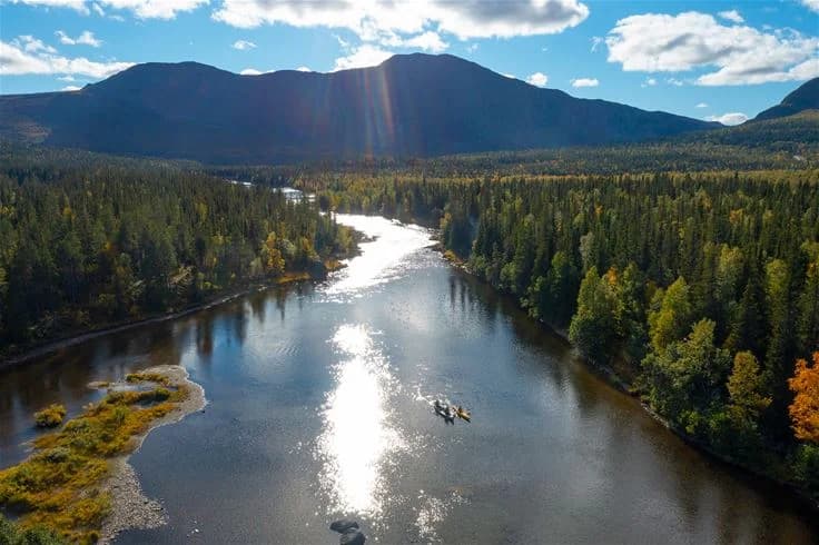 En vacker vy över en bergig landskap med en forsande flod, omgivet av orörd natur och höga berg vid Camp Kittelfjäll.